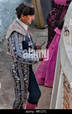 SAN MIGUEL DE Allende, Mexique-matador aiguise son couteau avant d'entrer dans le ring pour se battre. Vue de profil, le matador est pleinement en costume. Banque D'Images