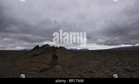 Une fissure sur un champ de lave le long de la route de montagne de l'arrière-pays F35 de l'intérieur de hautes terres d'Islande avec ciel couvert. Banque D'Images