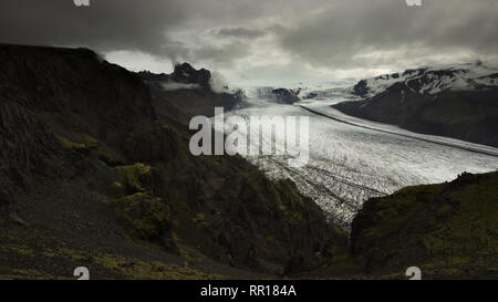 Glacier Skaftafellsjokull avec les nuages au-dessus du glacier et les montagnes autour d'un sentier de randonnée dans le parc national de Skaftafell, le sud de l'Islande. Banque D'Images