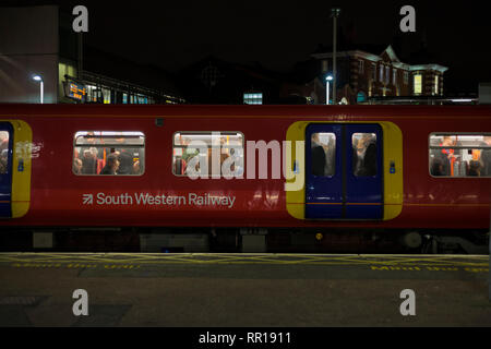 Les voyageurs ferroviaires sur un train en direction du sud-ouest de chemins loin de Londres à Clapham Junction dans l'heure de pointe du soir Banque D'Images