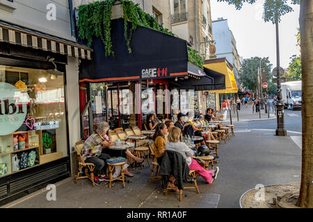 Personnes assises à l'extérieur sur le trottoir au café du marché des enfants rouges, rue de Bretagne, Paris, France Banque D'Images