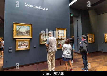 Personnes regardant tableaux impressionnistes et post-impressionnistes chefs-d au 5ème étage du Musée d'Orsay , une ancienne gare dans Paris , France Banque D'Images