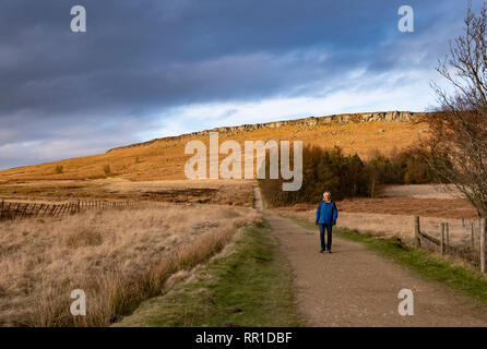 Homme marchant près de Stanage Edge, Peak District, UK en hiver Banque D'Images