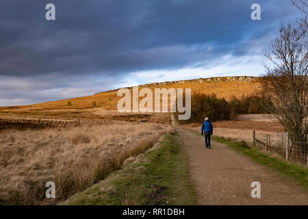 Homme marchant près de Stanage Edge, Peak District, UK en hiver Banque D'Images