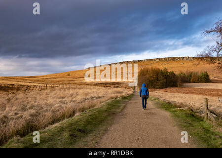 Homme marchant près de Stanage Edge, Peak District, UK en hiver Banque D'Images
