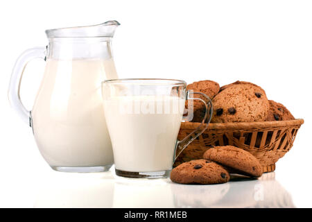 Verseuse et verre de lait avec des biscuits dans un panier en osier isolé sur fond blanc Banque D'Images