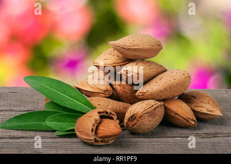 Des tas d'amandes dans leur peau et décortiquées avec feuille isolé sur fond blanc Banque D'Images