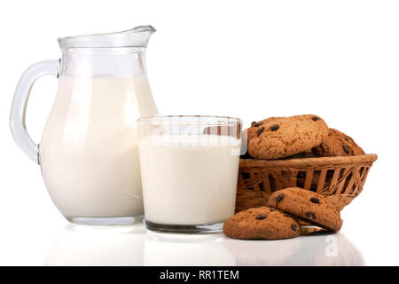 Verseuse et verre de lait avec des biscuits dans un panier en osier isolé sur fond blanc Banque D'Images