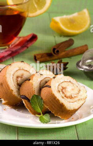 Biscuit rouleau suisse avec une tasse de thé vert sur fond de bois Banque D'Images