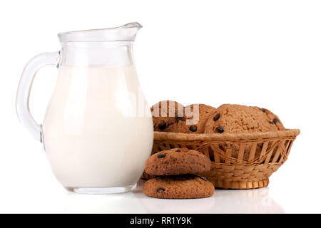 Verseuse et verre de lait avec des biscuits dans un panier en osier isolé sur fond blanc Banque D'Images