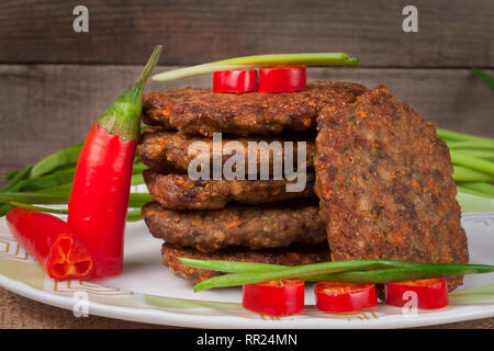 Escalopes de foie ou des crêpes avec le piment et les oignons verts sur un fond de bois Banque D'Images