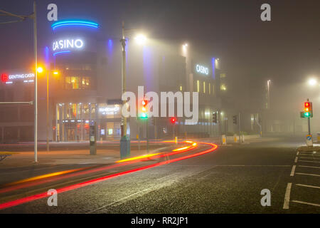 British Casino & Hotel Complex & car Light Trails à Southport, Merseyside. Brumeux, brumeux, brumeux, commencez la journée par une bruine légère, le centre-ville s'allume tôt le matin sur les trottoirs humides. Les feux de signalisation et les feux arrière des fêtards de la fin de la nuit utilisent des taxis à destination de la maison ; les feux des véhicules qui passent laissent des reflets sur la surface de la route. Crédit : MWI/AlamyLiveNews. Banque D'Images