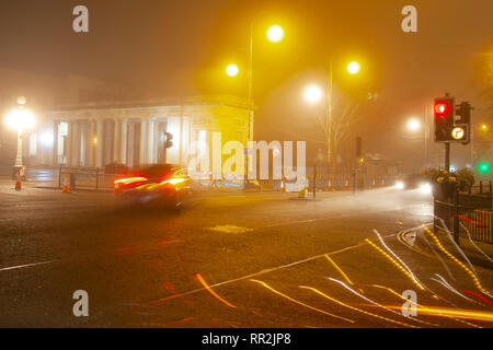 Southport, Merseyside. 24 Février, 2019. Météo britannique. Ciel voilé, brumeuse, Misty de commencer la journée avec une légère bruine tôt le matin circulation du centre-ville s'allume les chaussées humides. Sentiers de la circulation à partir de la fin de l'aide de noctambules homebound taxis ; que les lumières de passage des véhicules quitter réflexions sur la surface de la route. Indicateur/AlamyLiveNews : crédit. Banque D'Images