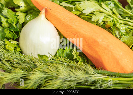 Arrière-plan de l'alimentation, les oignons et les carottes sur les verts closeup Banque D'Images