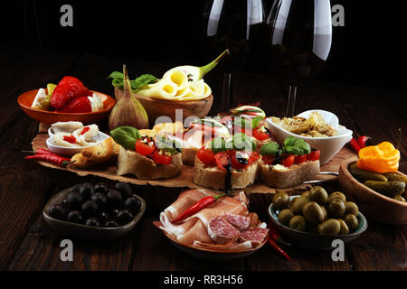 Vin antipasti italiens des en-cas. Variété de fromage, olives, cornichons Méditerranée, Prosciutto di Parma, les tomates, les artichauts et le vin dans les verres sur l'onglet Banque D'Images