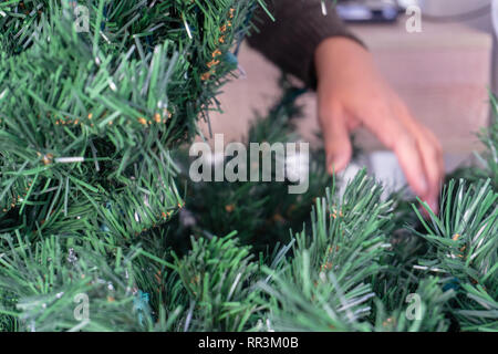 Démêler les mains un arbre de Noël artificiel sans ornements. Banque D'Images