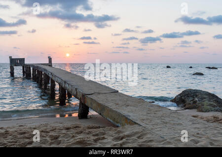 Plage de sable en premier plan et d'une jetée à l'horizon et le coucher du soleil en arrière-plan, photo de Long Beach, île de Phu Quoc Vietnam. Banque D'Images