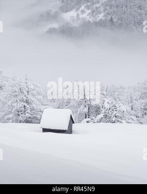 Paysage d'hiver fantastique avec maison en bois dans les montagnes enneigées. Concept de vacances de Noël Banque D'Images