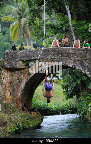 Un homme d'humeur sur une corde à l'ancien pont reliant espagnol St. Ann et paroisses Sainte Marie sur la rivière White, la Jamaïque. Banque D'Images