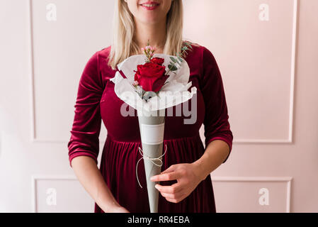 Pragnant femme tenant un bouquet de fleurs Banque D'Images