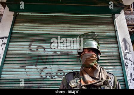 24 février 2019 - Srinagar, J&K, Inde - Un soldat paramilitaire vu l'article garde à l'avant d'un atelier fermé avec une restriction au cours de graffiti à Srinagar, au Cachemire indien.compétentes imposent des restrictions dans certaines parties de la ville en vue d'une grève déclenchée par les séparatistes contre la détention massive de plus de 150 leaders pour la liberté et les militants de l'avant d'une audience à la Cour suprême sur l'Article 35 A, qui prévoit des droits et privilèges à l'état de Jammu-et-Cachemire. Credit : Saqib Majeed/SOPA Images/ZUMA/Alamy Fil Live News Banque D'Images