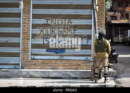 24 février 2019 - Srinagar, J&K, Inde - Un soldat paramilitaire vu l'article garde à l'avant d'un atelier fermé avec une restriction au cours de graffiti à Srinagar, au Cachemire indien.compétentes imposent des restrictions dans certaines parties de la ville en vue d'une grève déclenchée par les séparatistes contre la détention massive de plus de 150 leaders pour la liberté et les militants de l'avant d'une audience à la Cour suprême sur l'Article 35 A, qui prévoit des droits et privilèges à l'état de Jammu-et-Cachemire. Credit : Saqib Majeed/SOPA Images/ZUMA/Alamy Fil Live News Banque D'Images