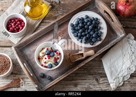 Une tasse de fromage cottage avec sol linseeds, bleuets et canneberges congelées, avec de groseille rouge et d'huile de graine de lin dans l'arrière-plan Banque D'Images