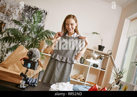 Il me convient bien, ne pensez-vous pas ? Jeune femme blogger enregistrement vidéo critique à propos de sa nouvelle robe et smiling at camera. Blog de mode. Les médias sociaux Banque D'Images