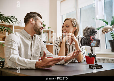 Sujet intéressant. Portrait de blogueurs positive de parler les uns avec les autres tout en streaming en ligne. Couple. Les médias sociaux. Blog. Content Banque D'Images