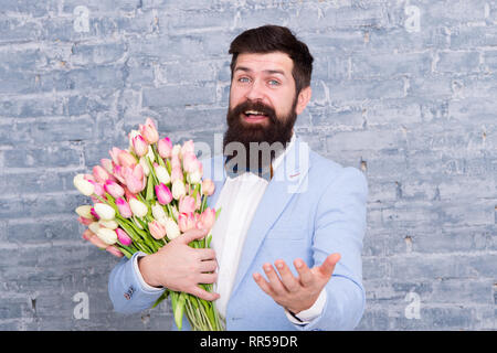 Cadeau romantique. Macho prêt date romantique. Tulipes pour ma chérie. L'homme grand Bow-tie tuxedo tenir fleurs bouquet. Comment être gentleman. Guide pour l'homme moderne. Homme romantique avec des fleurs. Banque D'Images