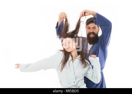 Bonjour monde. Rendez-vous à partir de la télévision à fluffy. heureux homme barbu jouer avec cheveux de sleepy girl. famille couple en robe. L'amour ses cheveux. La santé des cheveux et des soins. Je veux dormir. Matin couple endormi. Banque D'Images