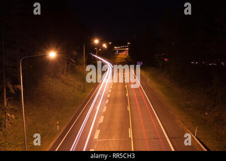 Une longue exposition photo de trafic avec des traces floues des voitures de nuit en Finlande, vue d'en haut. Banque D'Images