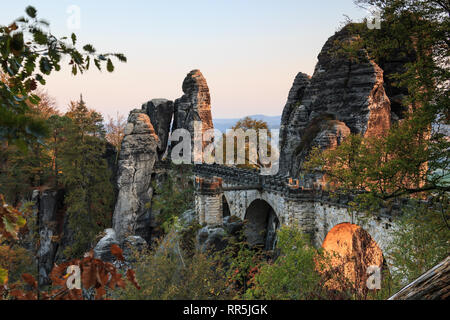 Bastei pont dans le soleil du soir avec rock formation. Montagnes de Grès de l'Elbe en Saxe La Suisse Saxonne Parc national avec les arbres en couleurs de l'automne. Banque D'Images