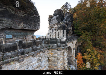 Vue de côté de la Bastei pont dans le parc national de la Suisse saxonne. Montagnes de grès de l'Elbe. Des formations rocheuses et arbres en automne. maçonnerie visible Banque D'Images