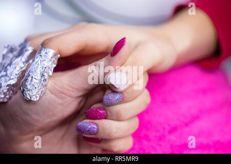 Women's main sur une serviette rose in nail salon. Banque D'Images