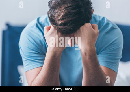 Portrait de l'homme en deuil couvrant le visage avec les mains et en pleurant à la maison Banque D'Images