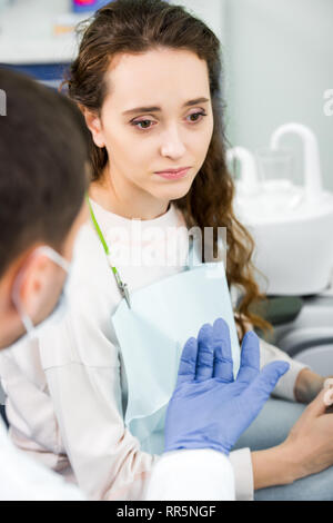 Portrait de femme pensive près de dentiste portant des gants en latex Banque D'Images