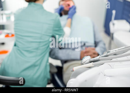 Focus sélectif d'instruments dentaires dentiste avec l'examen patient on background Banque D'Images