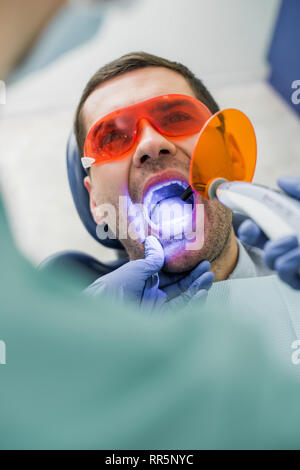 Focus sélectif de patient avec bouche ouverte pendant le blanchiment dentiste près de procédure Banque D'Images