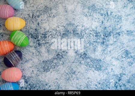 Les oeufs de pâques pastel colorés sur un fond de marbre bleu. Flatlay (jeter) contexte pour le printemps Banque D'Images