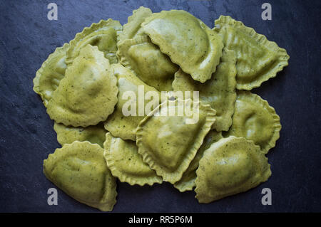 Mezzelune pâtes fraîches vert avec gorgonzola, speck et oignons caramélisés. Libre Banque D'Images