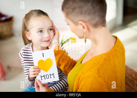 Jeune femme cancer patient remercier son adorable jeune fille pour des J'aime maman carte de vœux. Fête de famille concept. Happy Mother's Day Banque D'Images