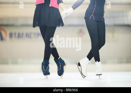 La section basse portrait de deux patineurs méconnaissable sur permanent patinoire en tenues mignonnes, copy space Banque D'Images