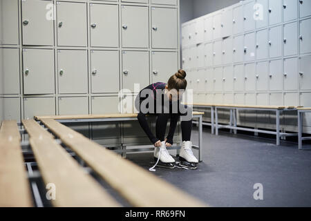 Portrait de petite fille lier des patins en dressing avant la pratique, copy space Banque D'Images