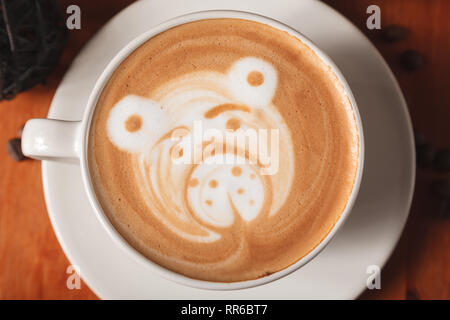 Tasse de cappuccino blanc avec une latte art-modèle dans la forme d'un ours gros plan sur un fond de bois. Le concept de faire le café dans un s Banque D'Images