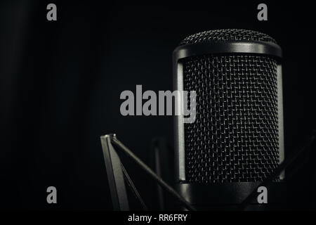 Close up d'un micro studio à droite de l'image sur un fond sombre, aspect horizontal. Banque D'Images