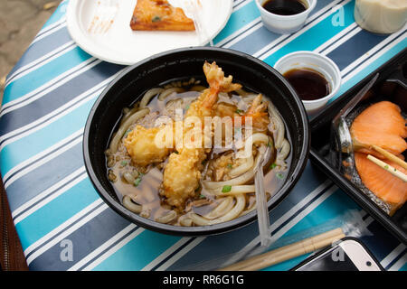 Les nouilles Udon ou soupe de nouilles de style japonais, avec la garniture de crevettes tempura croustillante sur table en plein air au jardin du Japon village de Ayutthaya, Thaïlande Banque D'Images