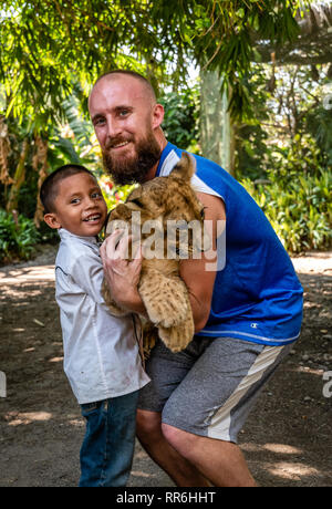 L'enfant and Caucasian man holding baby lion zoo au Guatemala Banque D'Images