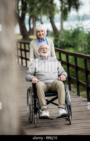 Focus sélectif de nice woman avec son mari en fauteuil roulant sur le pont en bois Banque D'Images