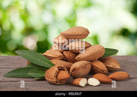 Des tas d'amandes dans leur peau et décortiquées avec feuille isolé sur fond blanc Banque D'Images